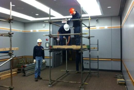 Workers assembling indoor scaffolding