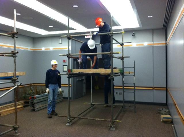 Workers assembling indoor scaffolding