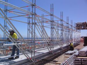 Workers installing pipe and frame scaffolding system at a construction site in Brooklyn NYC