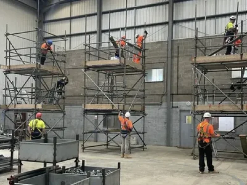 Workers training on scaffold towers in an indoor facility